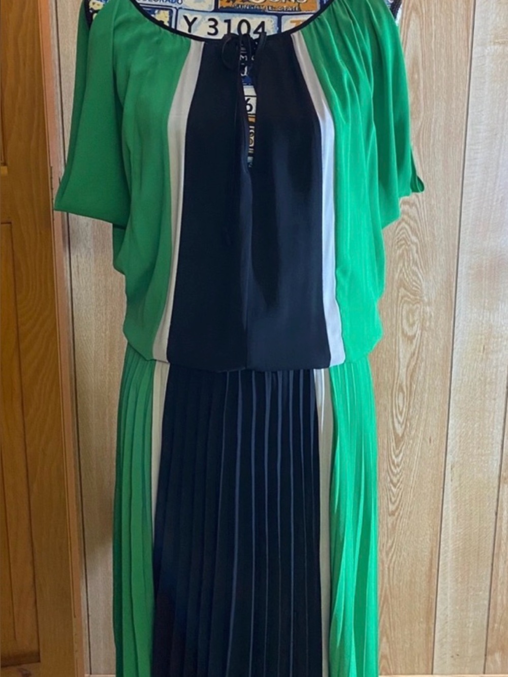 Chic green and black pleated midi skirt featuring contrasting white trim.